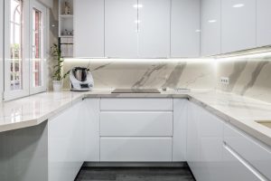 Encimera de cocina en porcelánico con brillo con faldón y forrado en pared.